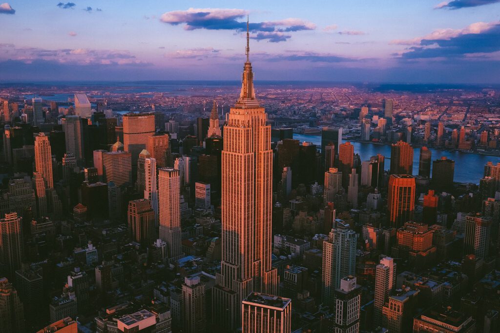 Landscape aerial photo of the Empire State Building against an evening city skyline