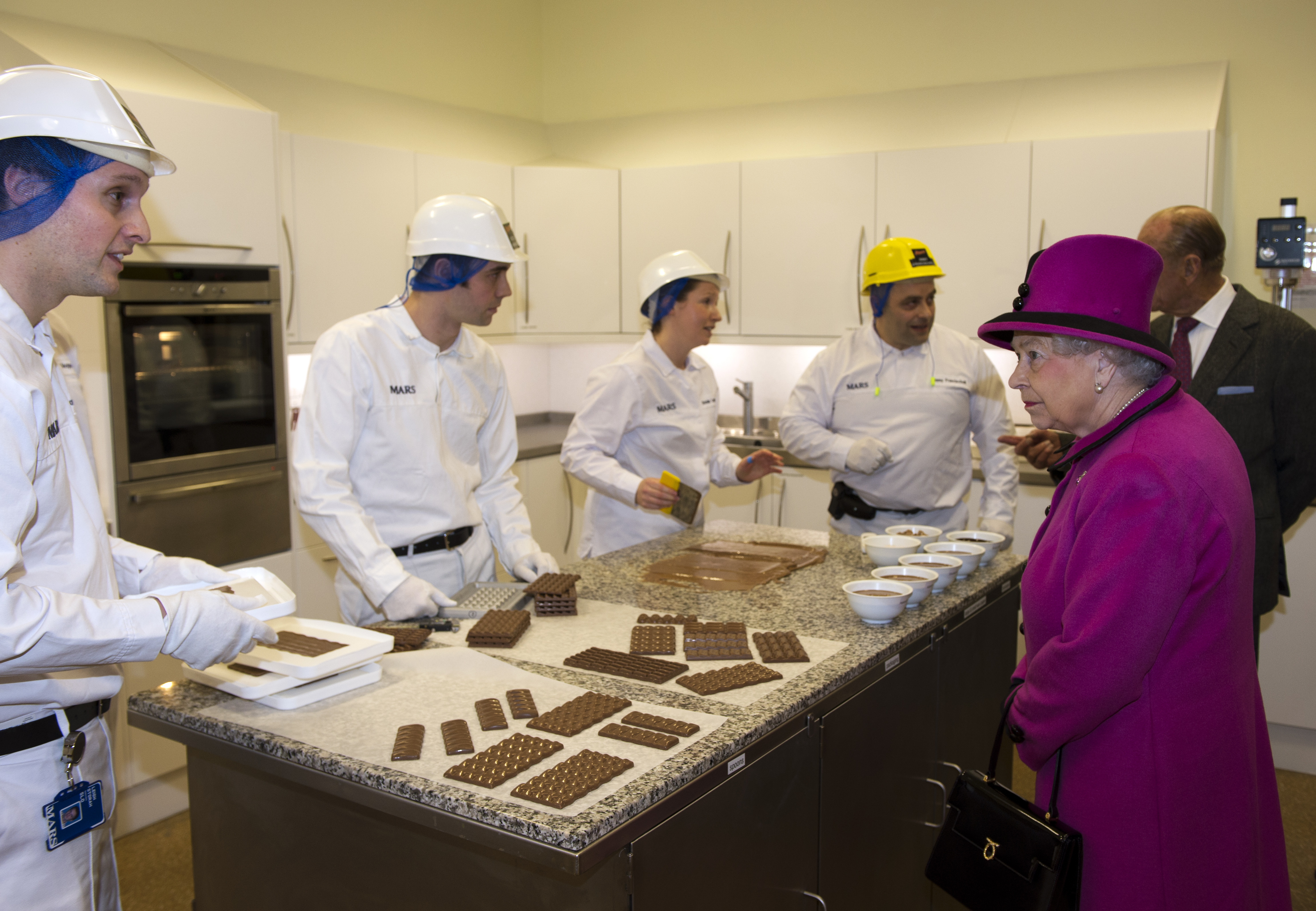 Queen Elizabeth II (R) meets members of staff at the innovation department during a visit to Mars Chocolate UK in Slough, southern England on April 5, 2013.