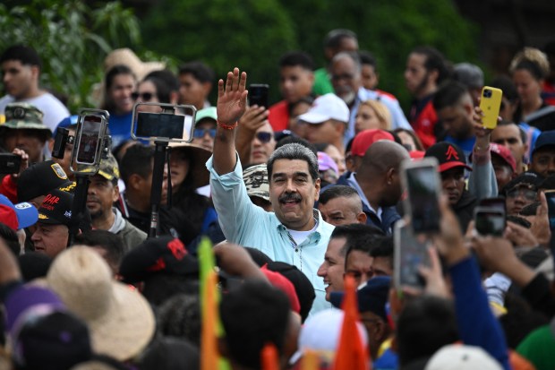 Nicolas Maduro greets supporters upon his arrival at a rally marking the anniversary of the Battle of Santa Ines, in Caracas on December 10, 2025.