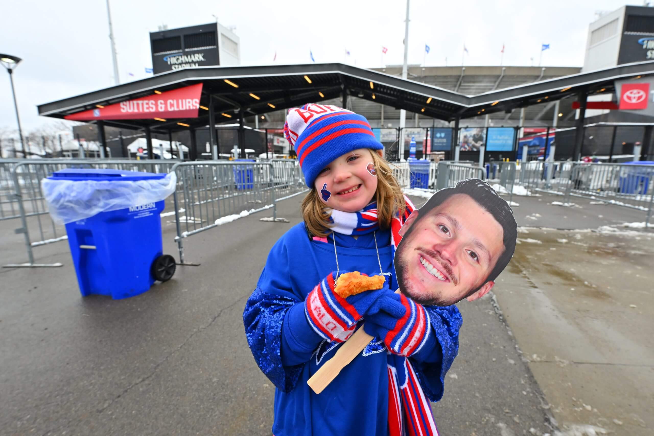 A young Bills fan holds a cutout photo of Josh Allen's headshot outside Highmark Stadium in January 2026.