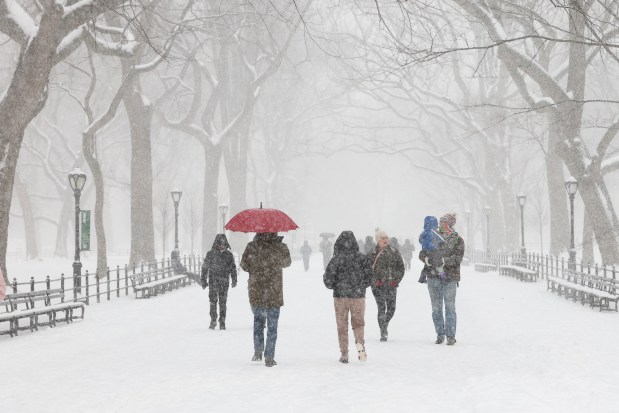 People walk in Central Park as snow falls in New York City on January 25, 2026. A massive winter storm on January 24 dumped snow and freezing rain from New Mexico to North Carolina as it swept across the United States towards the northeast, threatening tens of millions of Americans with blackouts, transportation chaos and bone-chilling cold. After battering the country's southwest and central areas, the storm system began to hit the heavily populated mid-Atlantic and northeastern states as a frigid air mass settled in across the nation. (Photo by TIMOTHY A.CLARY / AFP via Getty Images)