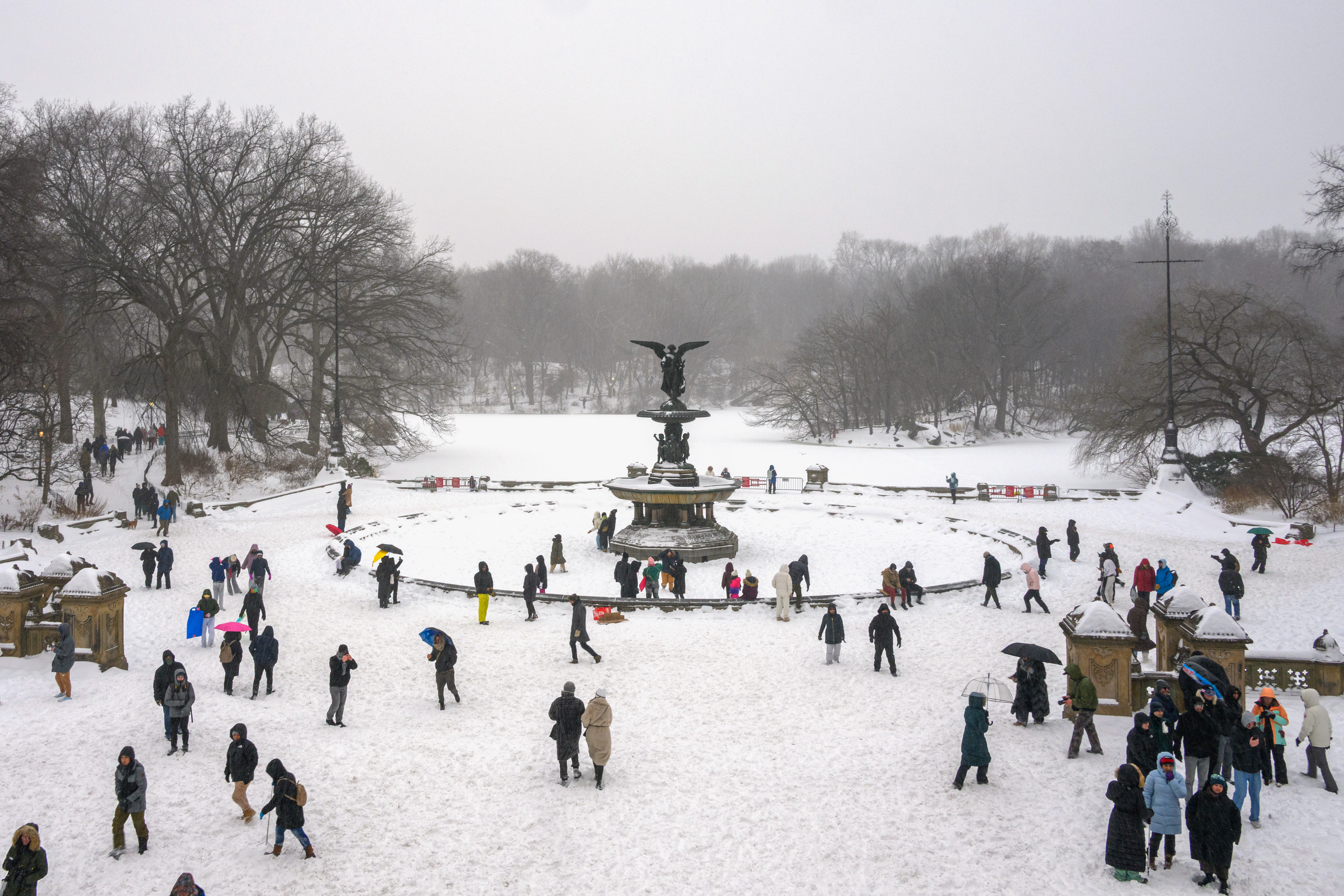 People walk through the snow around Bethesda Fountain in Central Park.