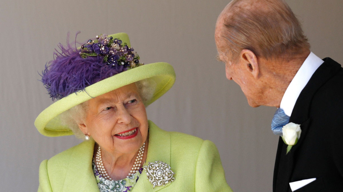 Queen Elizabeth smiles in a key-lime green jacket and matching hat at Prince Philip at George's Chapel after the wedding between Prince Harry and Meghan Markle
