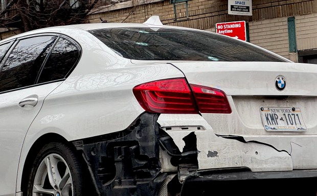 Bullet holes are pictured in the rear windshield of a white BMW as it's towed away from the scene on Friday, Jan. 9, 2026. (Rebecca White / New York Daily News)