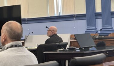 michael fisher and his attorney sit in a courtroom