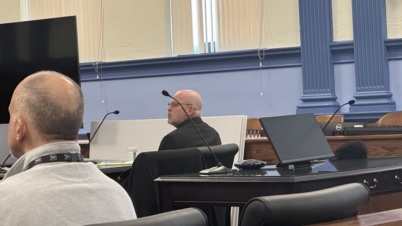 michael fisher and his attorney sit in a courtroom