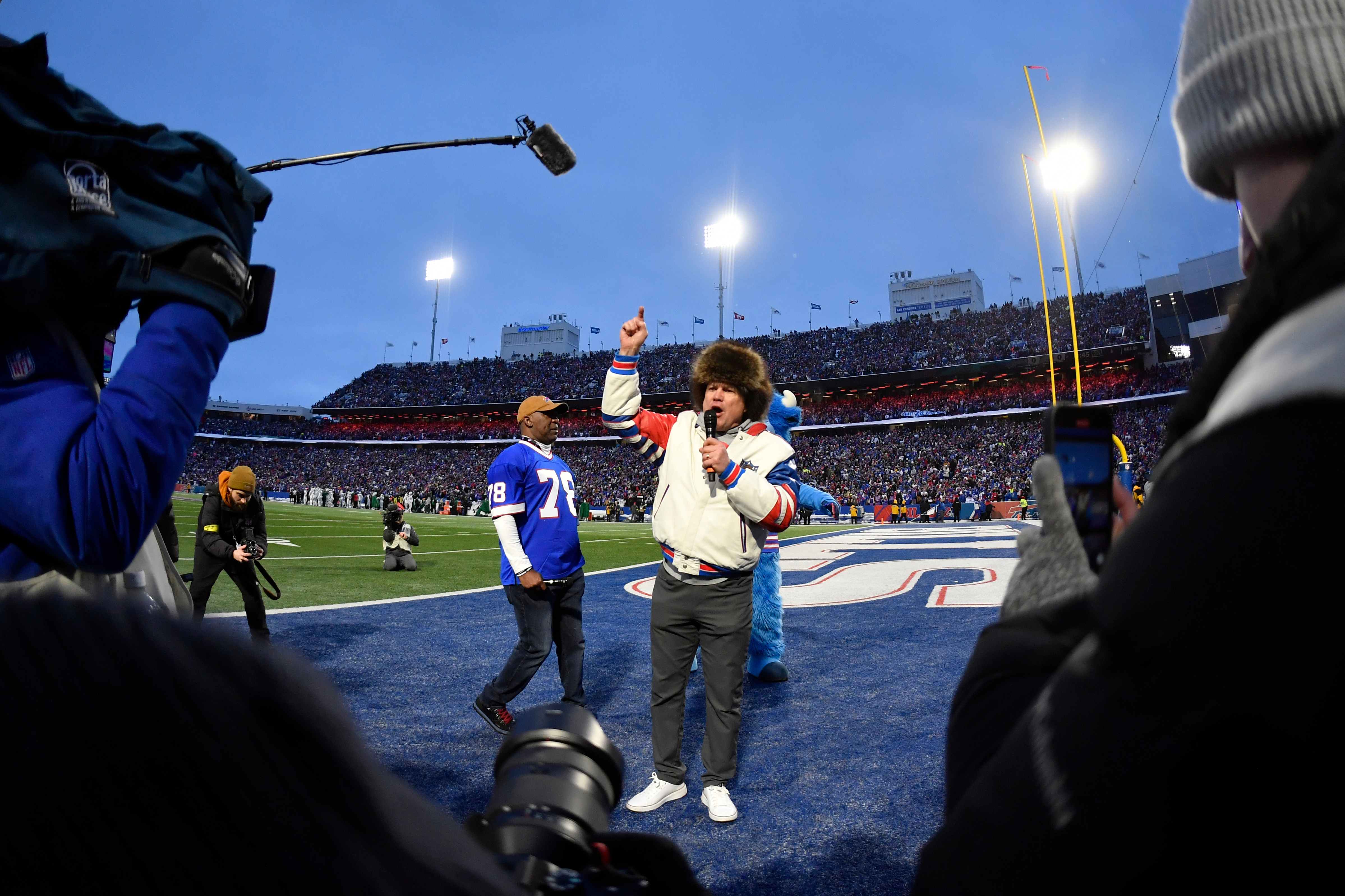Former Buffalo Bills players Steve Tasker, center, and Thurman Thomas (78) lead the crowd in cheers before the start of an NFL football game between the Bills and the New York Jets Sunday, Jan. 4, 2026, in Orchard Park, N.Y. (AP Photo/Adrian Kraus)