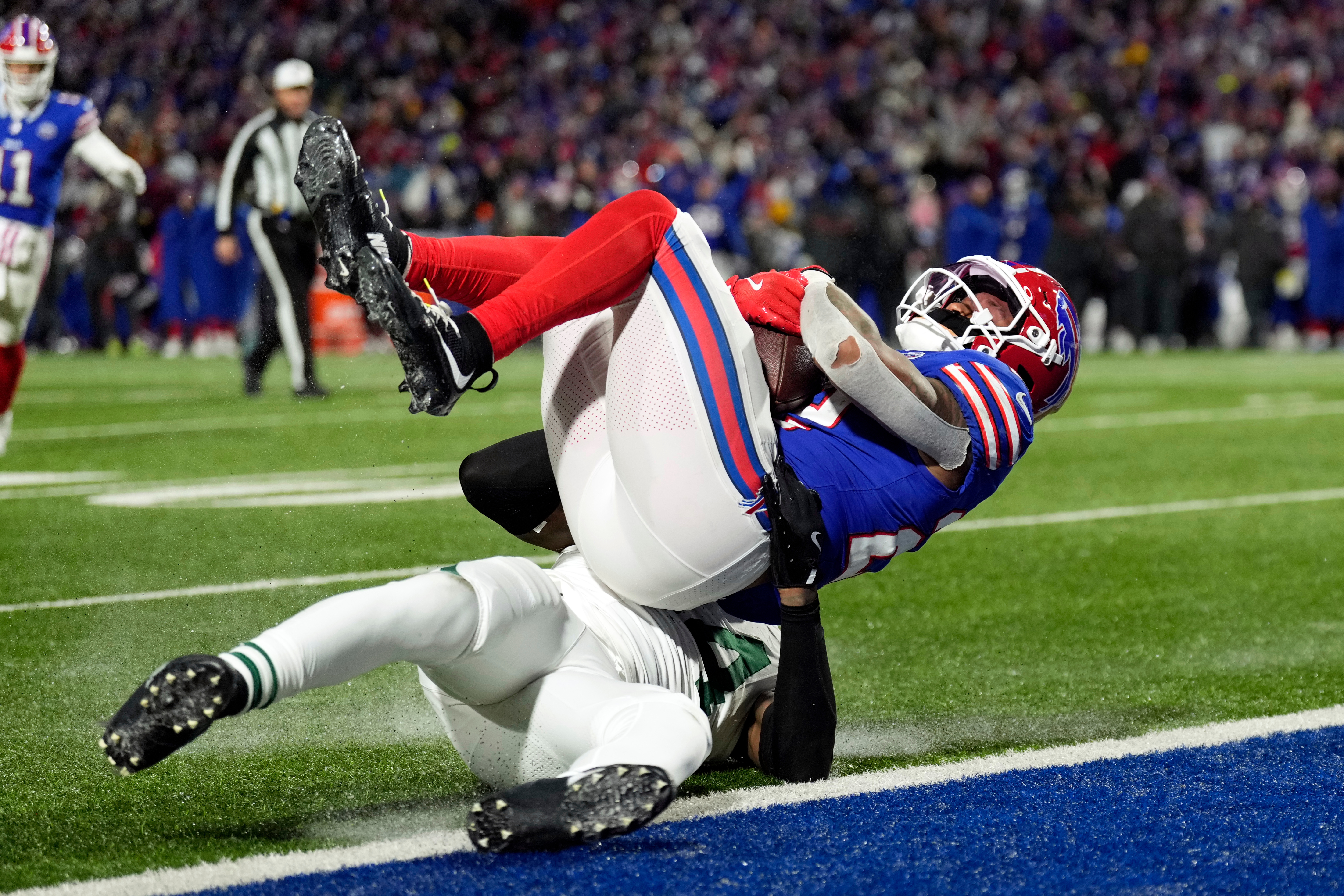 Buffalo Bills running back Ray Davis, top, falls over New York Jets linebacker Jamien Sherwood, bottom, as Davis scores a touchdown in the first half of an NFL football game Sunday, Jan. 4, 2026, in Orchard Park, N.Y. (AP Photo/Seth Wenig)