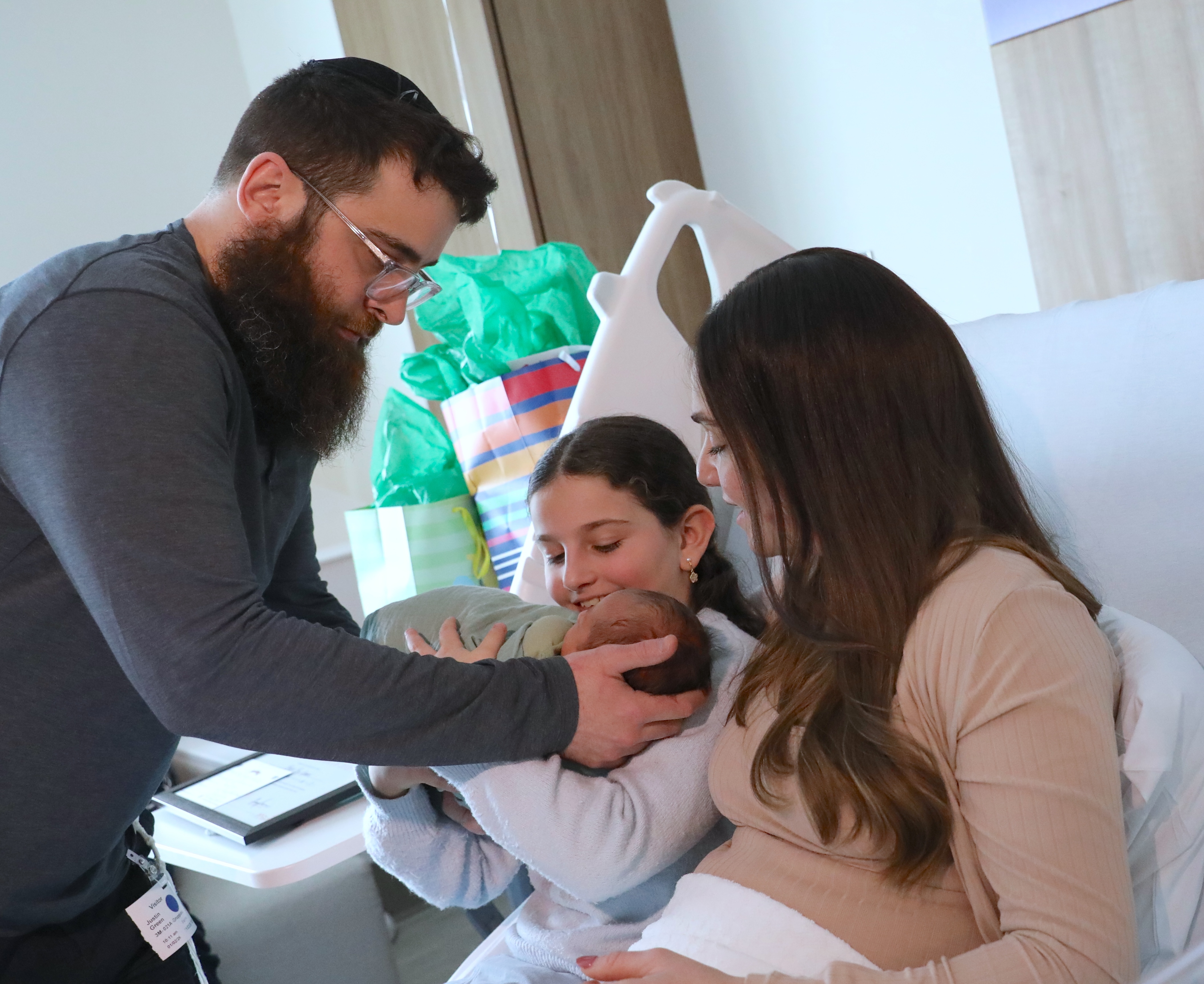 Baby boy Green was born on Thursday, Jan. 1, at 3:50 a.m. at Northwell Staten Island University Hospital, Ocean Breeze. The Staten Island Ferry Hawks general manager and front office staff  visited them today to declare them Ferry Hawks family of the year.  Justin Green places baby boy in his sister Zohars arms as mom, Chaya looks on. (Advance/SILive.com | Jan Somma-Hammel)
