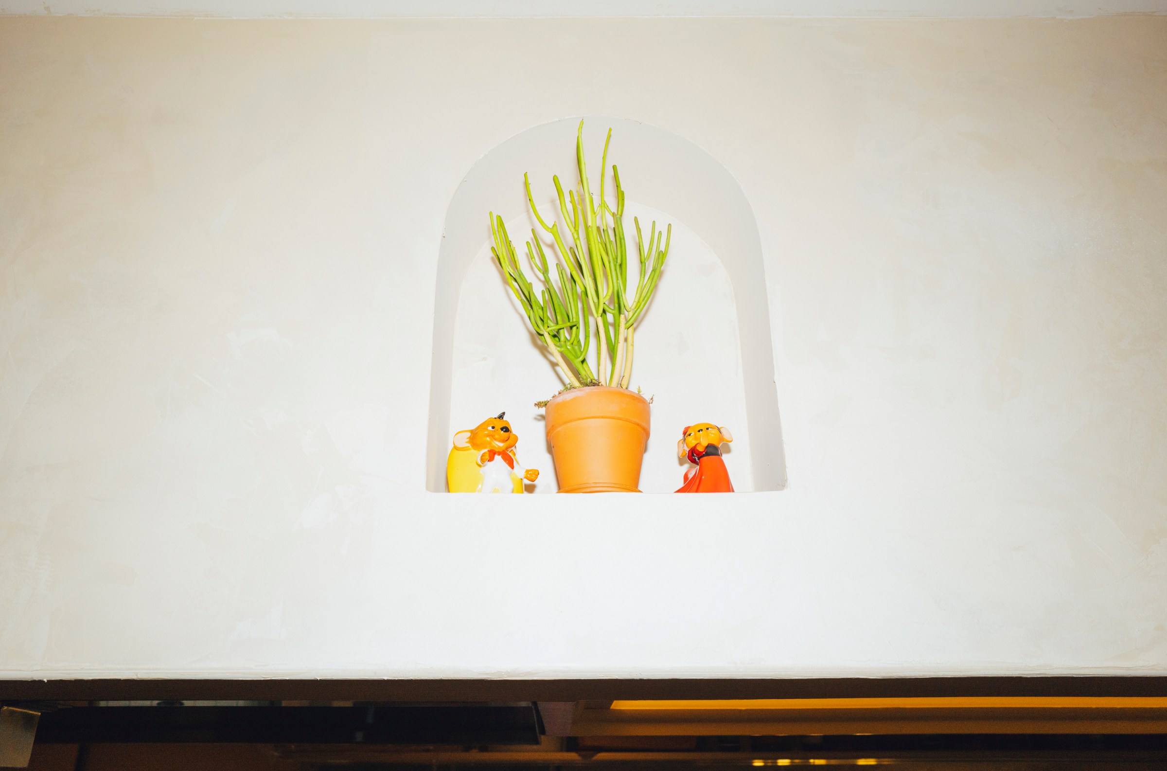 An oval-shaped inset shelf with a plant and toys.
