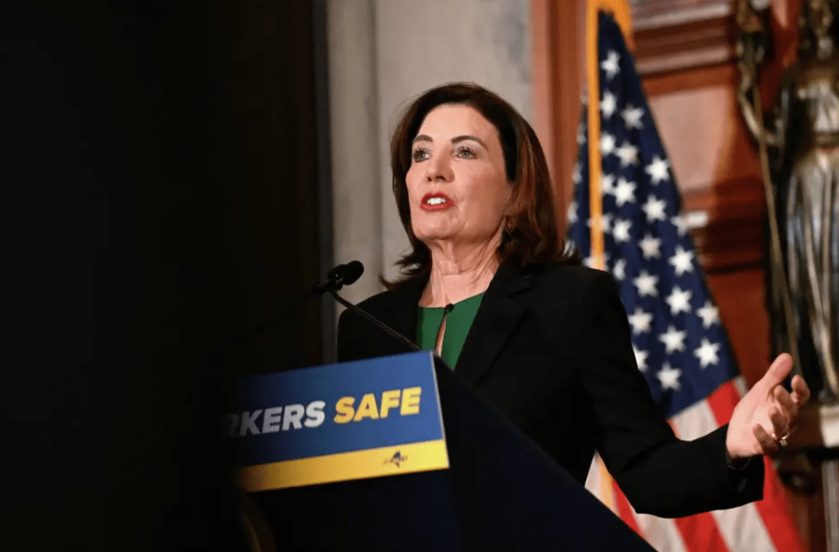Gov. Kathy Hochul speaks at a podium with US flag behind her 