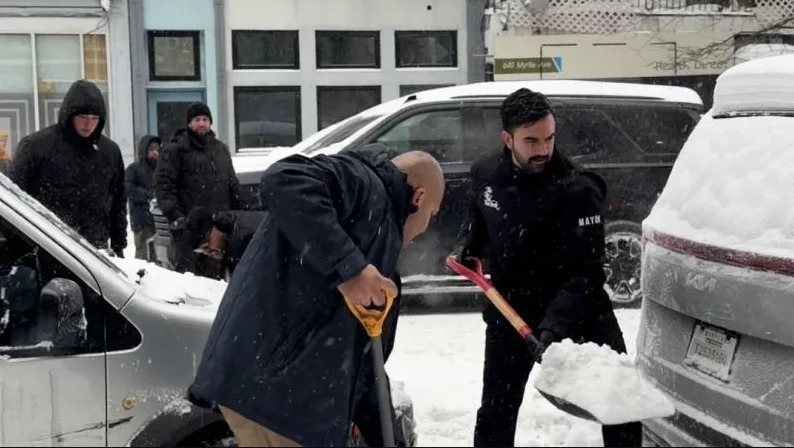 Mayor Zohran Mamdani assists drivers as heavy snowfall leaves cars stuck on a Brooklyn street during the weekend storm.
