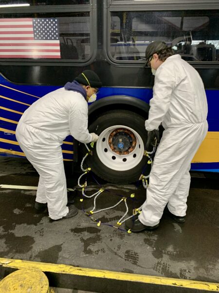 An MTA team fit snow chains onto the rear tires of transit buses on Friday. Photo: Mary Frost, Brooklyn Eagle