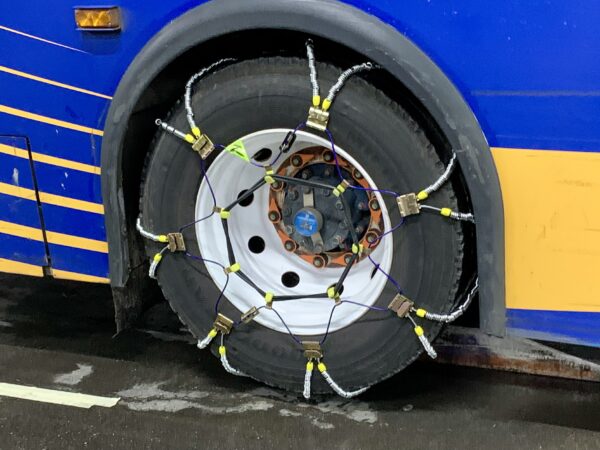 It took an MTA crew under a minute to fasten this snow chain around a bus tire on Friday. Photo: Mary Frost, Brooklyn Eagle
