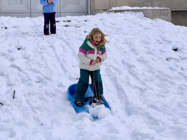 ‘I did it!’ This girl managed to stay in her feet as she “snowboarded” down the steps of the War Memorial. Photo: Mary Frost, Brooklyn Eagle