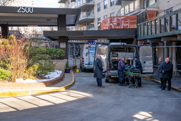 Medical Examiner workers remove a body from the apartment building on Johnson Ave. in the Bronx on Thursday.