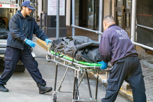 Medical Examiner workers remove a body from the apartment building on Johnson Ave. in the Bronx on Thursday.