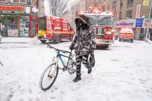 A man pushing along his bicycle during a snow storm in the Bronx on Sunday January 25, 2026. 0729. (Theodore Parisienne / New York Daily News)