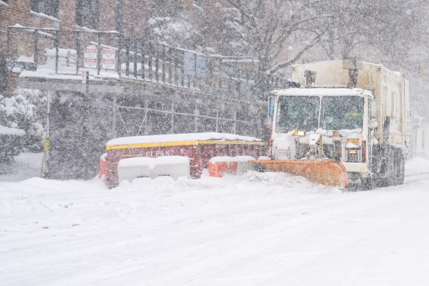 Snow plow pushes through the streets of the Bronx on Sunday.