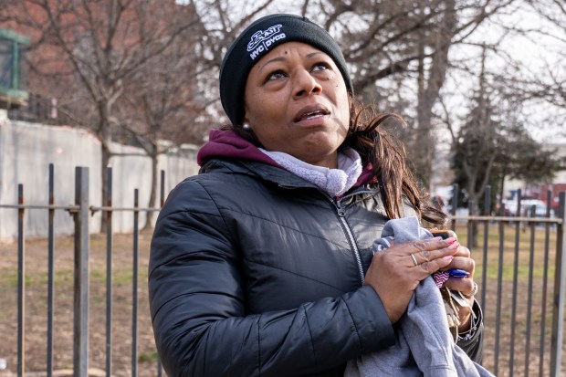 Building resident Delores Singleton looks up at the damaged high-rise on Saturday morning. (Theodore Parisienne / New York Daily News)