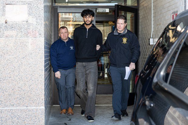 BMW driver Tegh Pawar, 24, center, who was allegedly involved in a fatal crash on the Belt Parkway in Queens, is pictured in police custody leaving the NYPD's 112th Precinct stationhouse on Tuesday, Jan. 20, 2026. (Shawn Inglima/ New York Daily News)