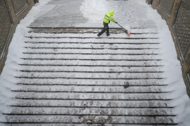 A worker clears snow from the steps of Bethesda Terrace in Central Park.