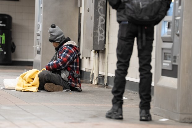 A homeless person takes shelter from the extreme cold in the Herald Square subway station Tuesday, Jan. 27, 2026.