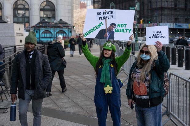 Supporters of Luigi Mangione raise signs outside Manhattan federal court, Friday, Jan. 9, 2026, in New York. (AP Photo/Yuki Iwamura)