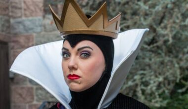 The Evil Queen from Snow White, in her signature gold crown and high white collar, greets guests at the park.