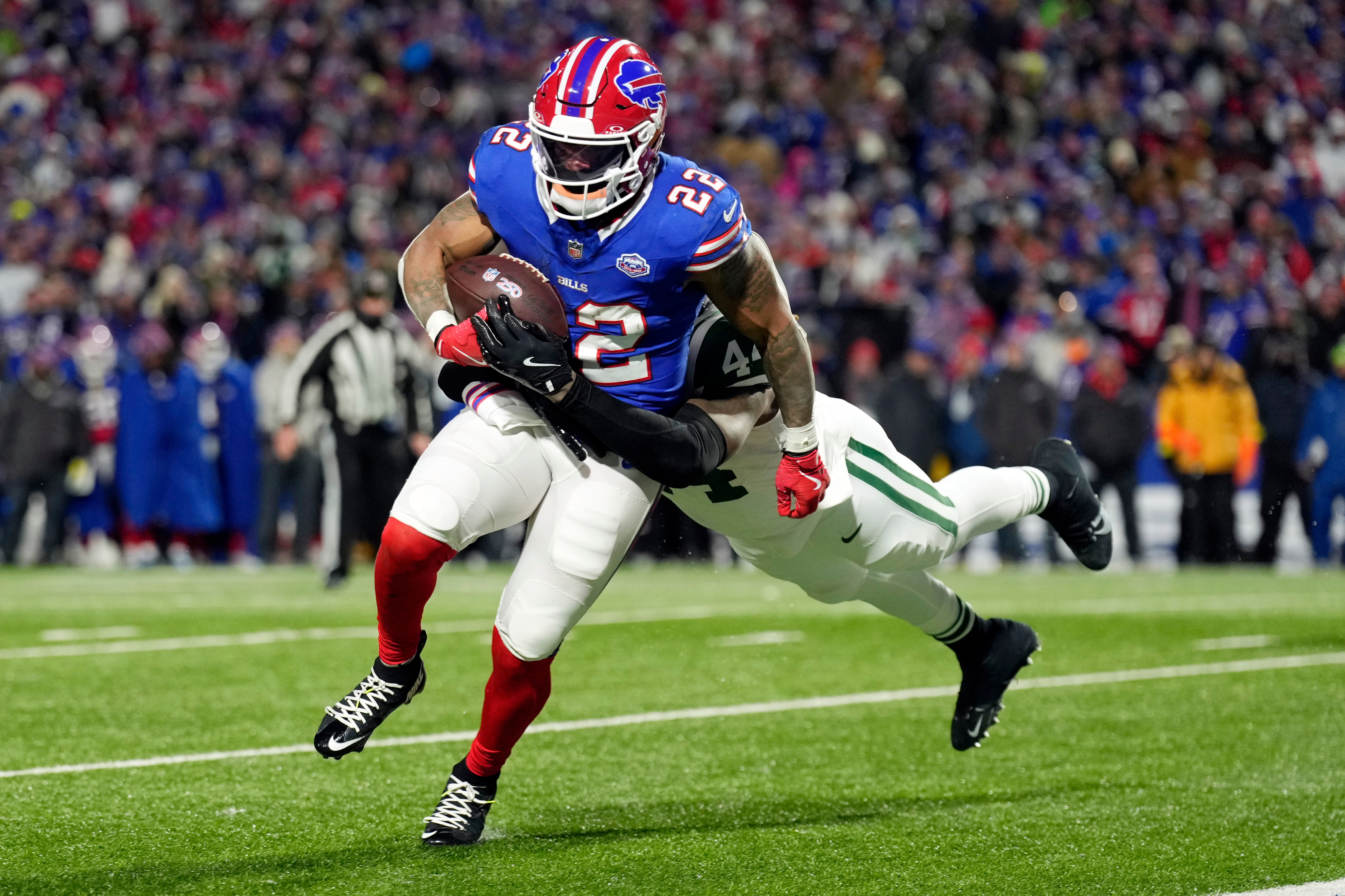 Buffalo Bills running back Ray Davis (22) pulls along New York Jets linebacker Jamien Sherwood (44) as Davis scores a touchdown in the first half of an NFL football game Sunday, Jan. 4, 2026, in Orchard Park, N.Y. (AP Photo/Seth Wenig)