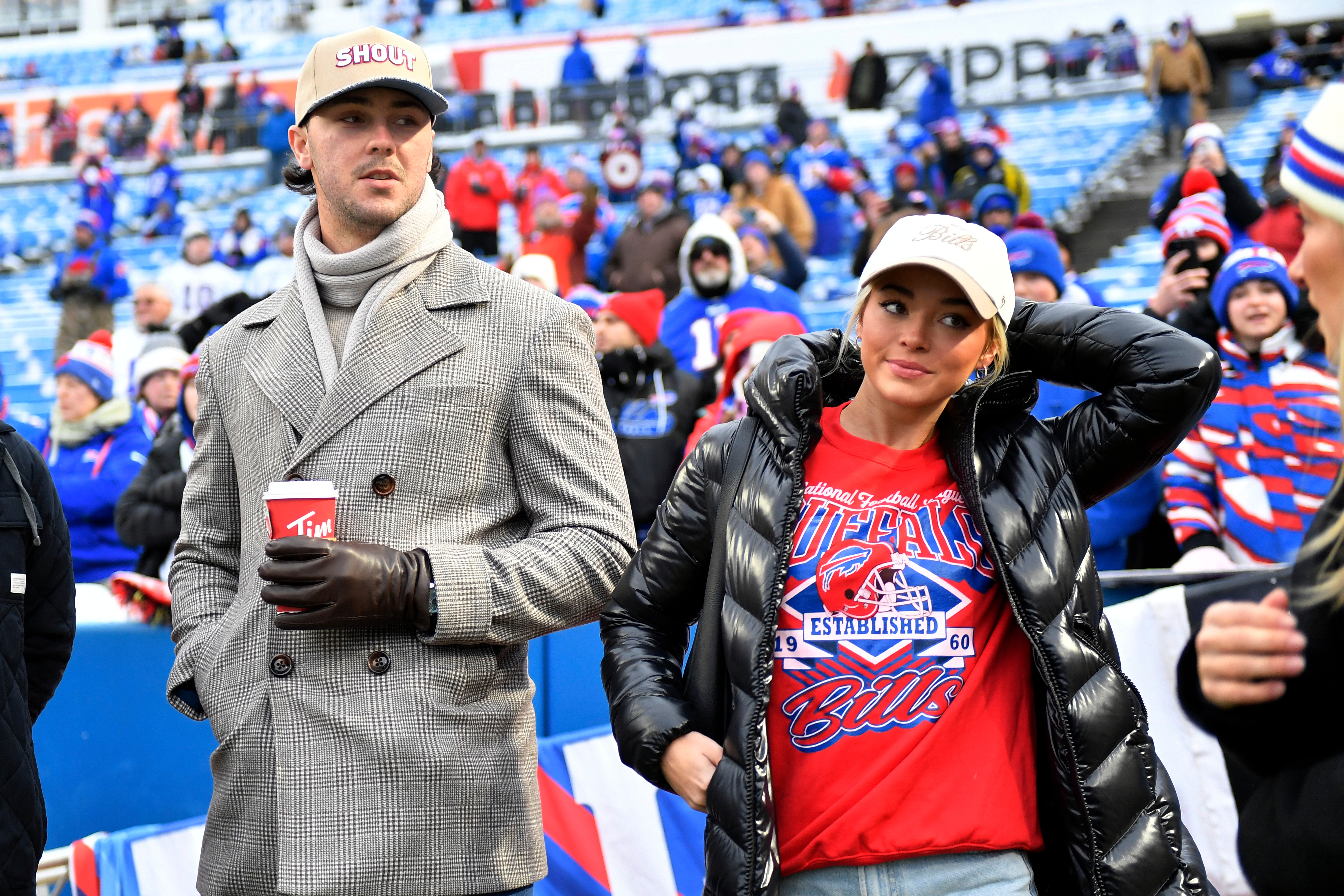 Pittsburgh Pirates pitcher Paul Skenes, left, and girlfriend, former gymnast Livvy Dunne, right, watch players warm up before an NFL football game between the Buffalo Bills and the New York Jets Sunday, Jan. 4, 2026, in Orchard Park, N.Y. (AP Photo/Adrian Kraus)