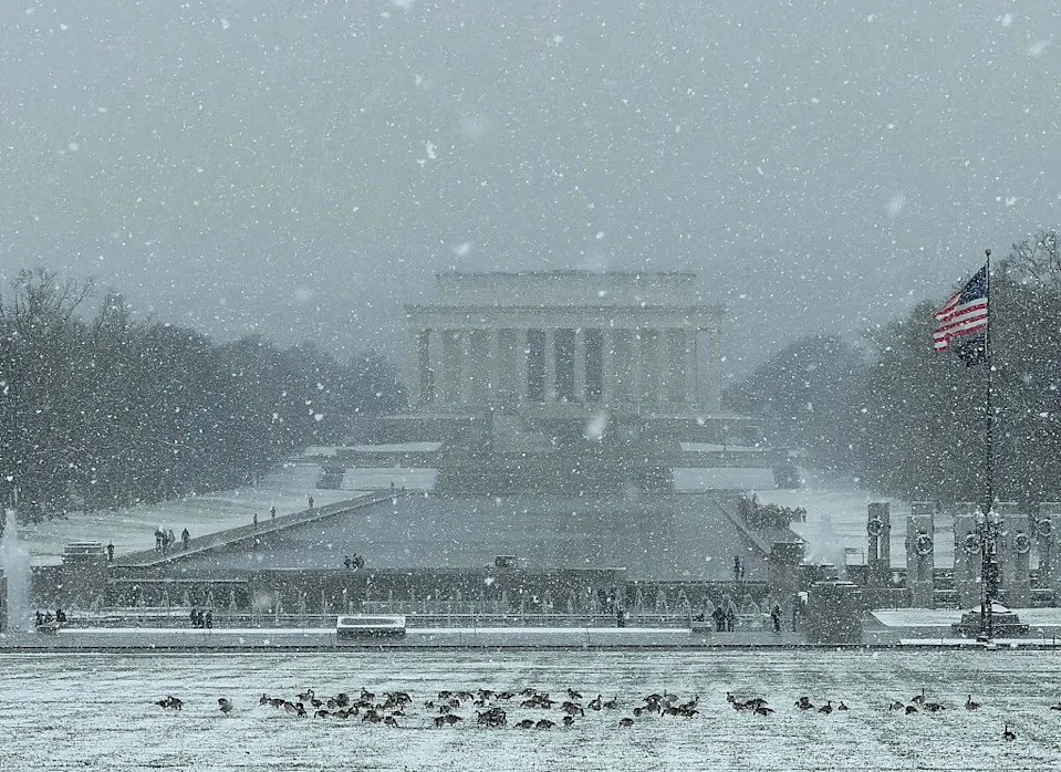 05 December 2025, USA, Washington: Snow lies in front of the Lincoln Memorial (background) during the first snowfall of the winter season.