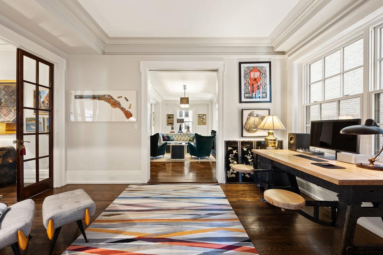 Modern living space with an open layout featuring a desk and artwork.