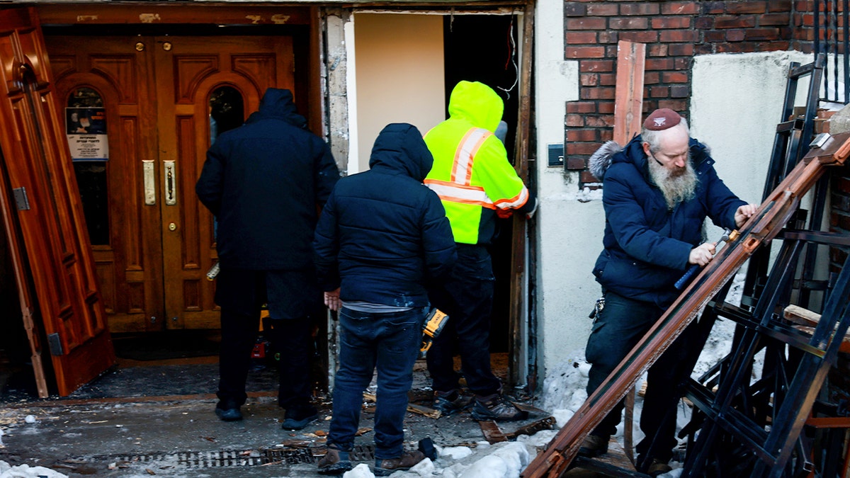 People repair door at Chabad's headquarters after car-ramming incident