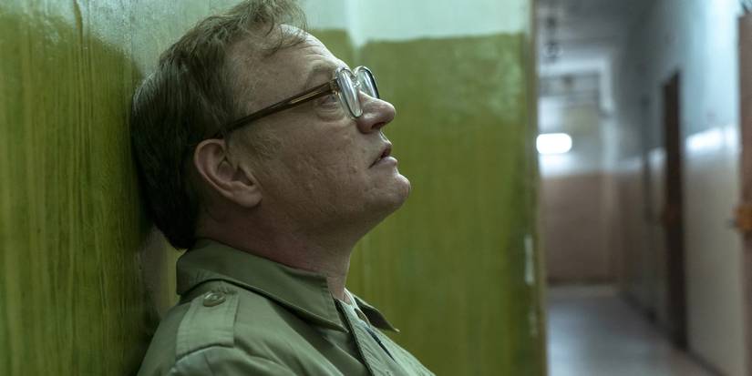 Jared Harris as Valery Legasov leaning against a wall in Chernobyl (2019).