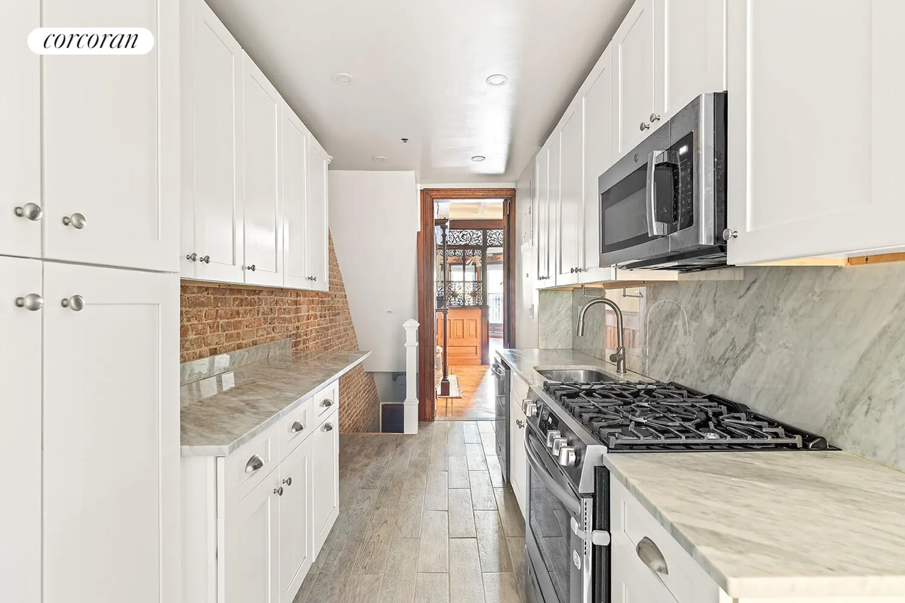 kitchen with white cabinets, marble counters, staircase downstairs