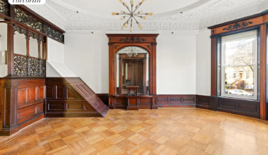 parlor with wainscoting, plasterwork, fretwork, wood floor