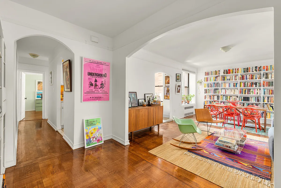 foyer with arched opening to a living room with wall of bookcases