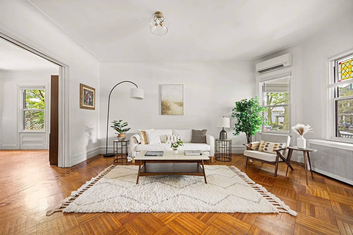 a living room with a wood floor and a stained glass window