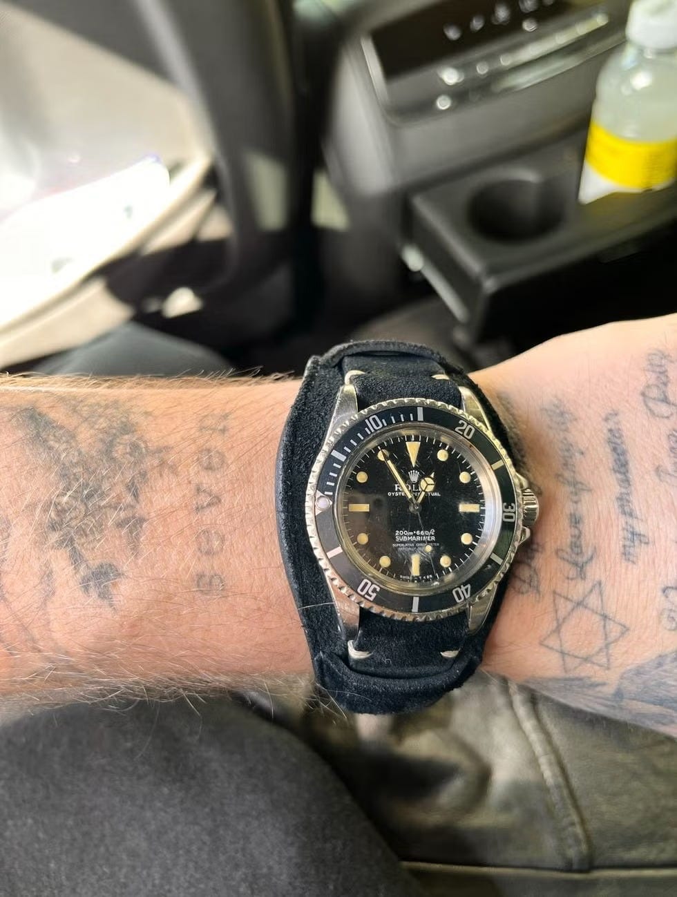 wristwatch displayed on a tattooed arm in a vehicle wristwatch displayed on a tattooed arm in a vehicle