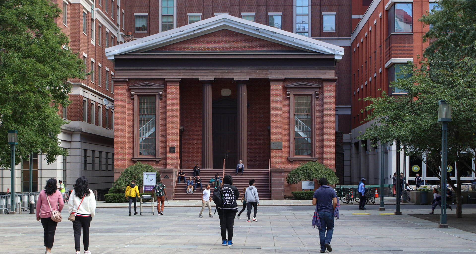 people walking in front of a temple front building
