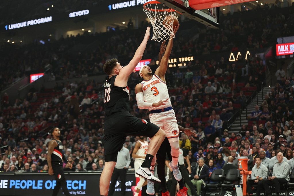 Josh Hart of the New York Knicks drives to the basket as Donovan Clingan of the Portland Trail Blazers defends.