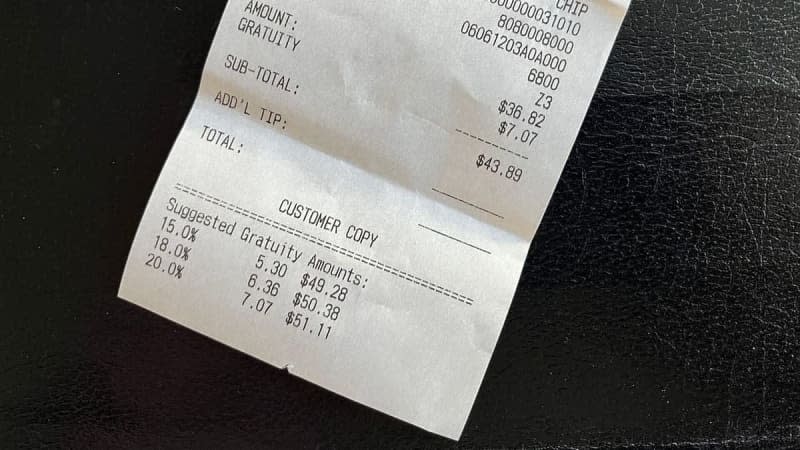 A restaurant receipt shows the bill total with suggested gratuity amounts of 15%, 18% and 20%. Photo: Alan Wooten / The Center Square