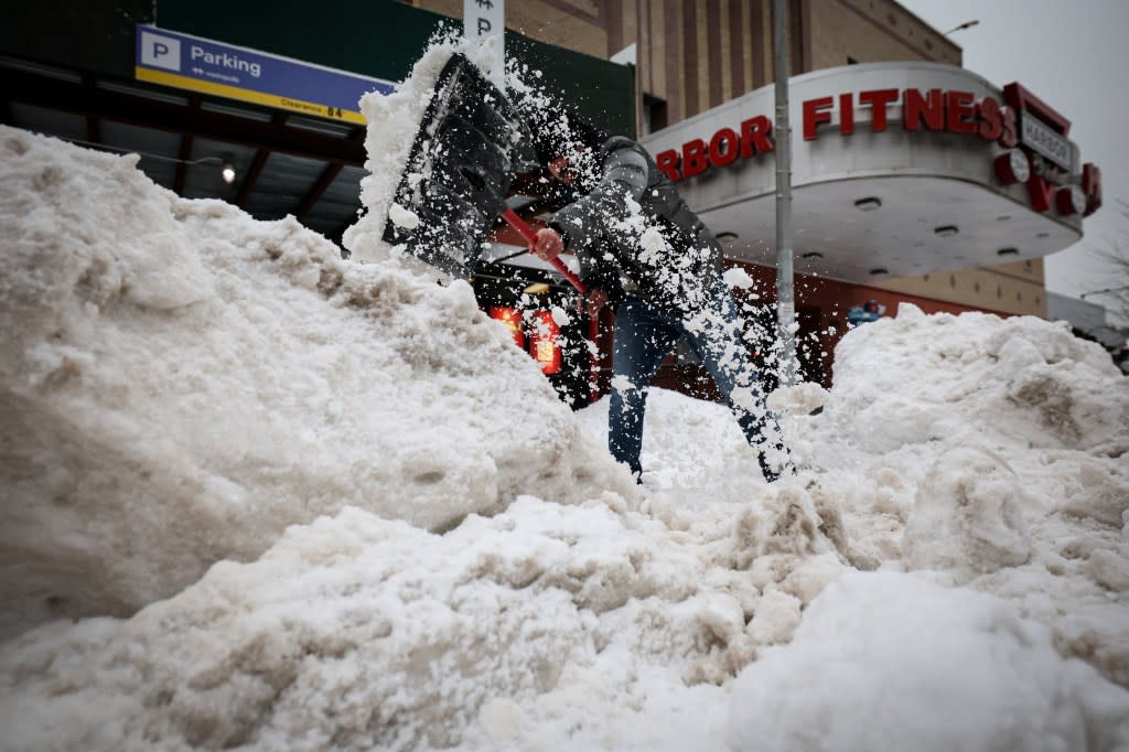 A worker clears snow from the entrance to a parking lot during Winter Storm Fern in New York City. REUTERS