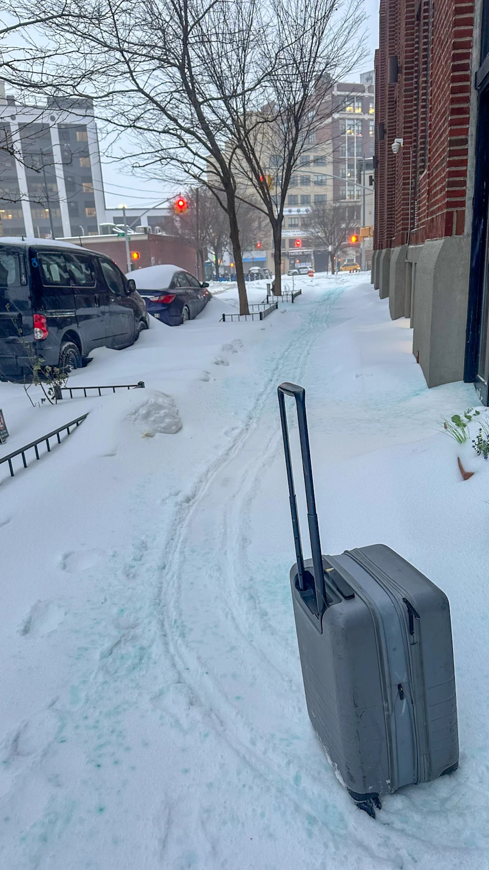 Grey suitcase in the snow in Queens, New York