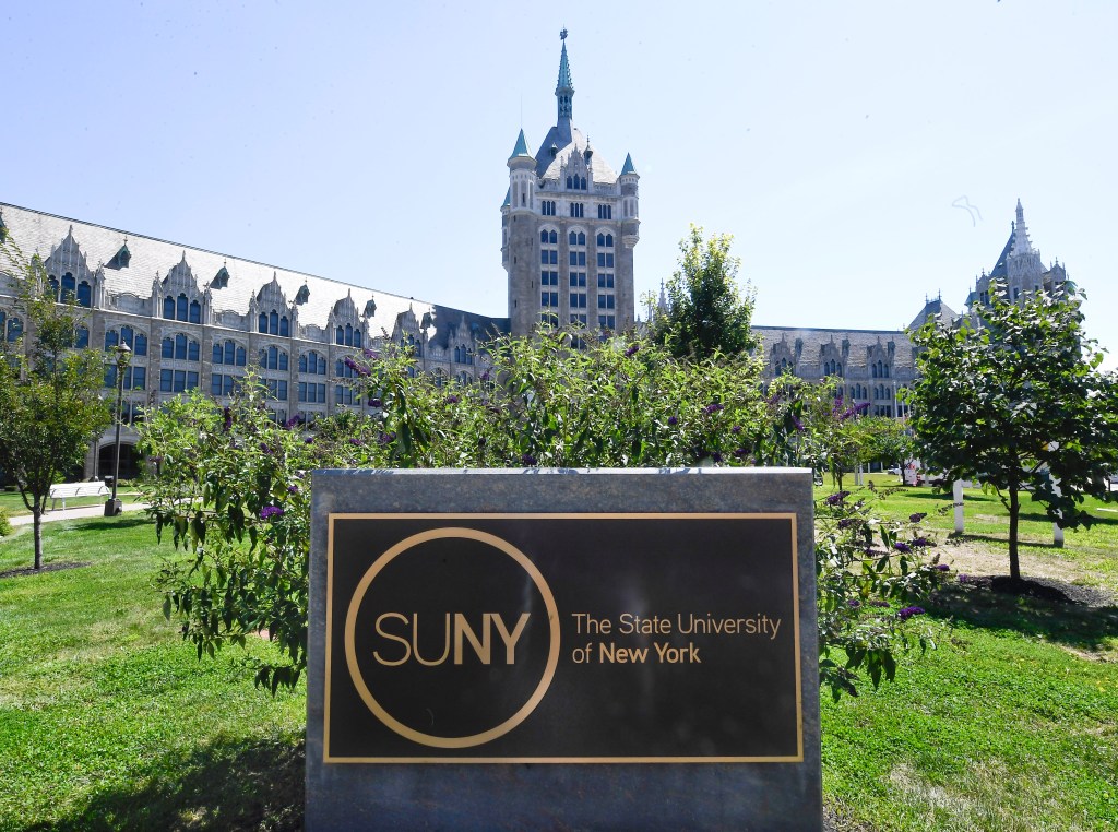 The State University of New York administrative building with a SUNY sign in the foreground.