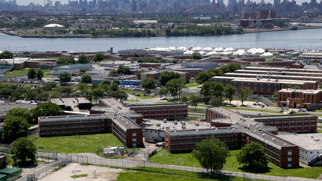 This June 20, 2014 file photo shows the Rikers Island jail complex in New York with the Manhattan skyline in the background. (AP Photo/Seth Wenig, File)