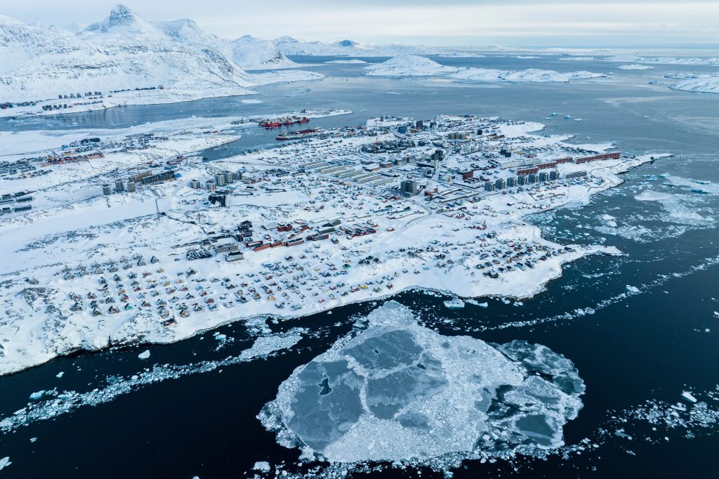 Aerial view of houses covered by snow on the coast of a sea inlet of Nuuk, Greenland.