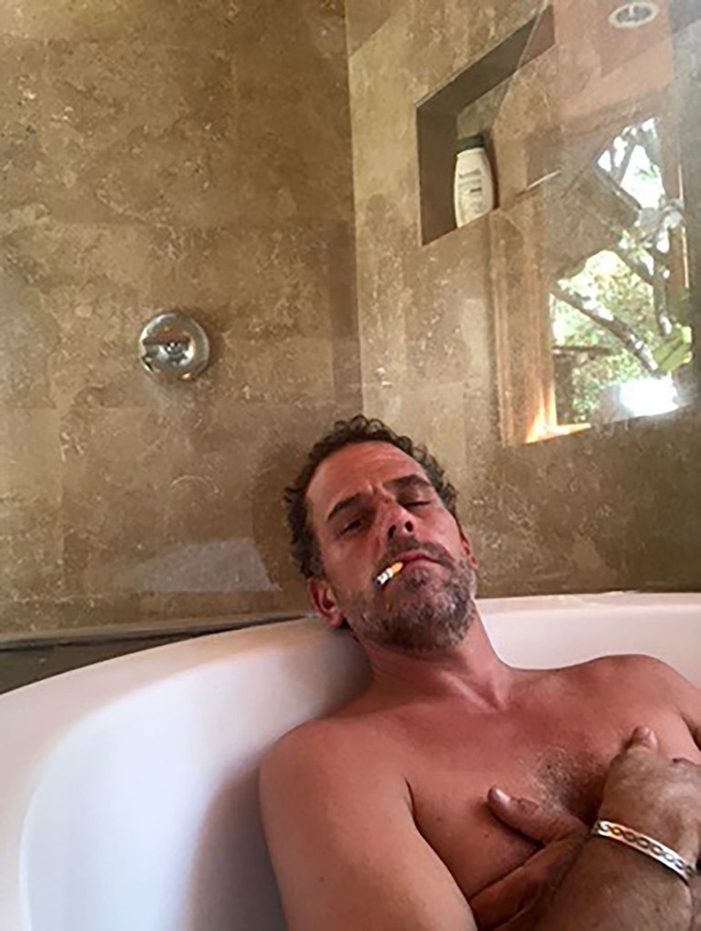 Hunter Biden lying in a bathtub with a cigarette in his mouth, wearing a bracelet, and holding his chest.