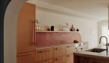 KITCHEN WALL OF WOOD CABINETS RED TILE WORK WITH CURVE